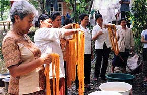 Vrouwen van Panmai controleren de geverfde zijde voor de sjaals